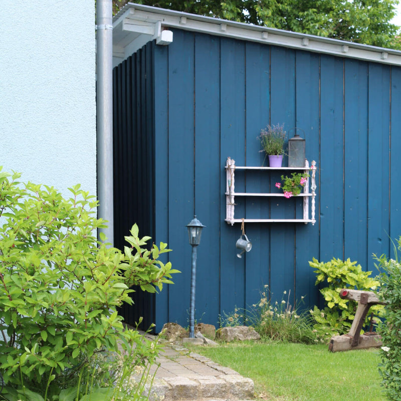 Seitenansicht einer blau gestrichenen Holzhütte