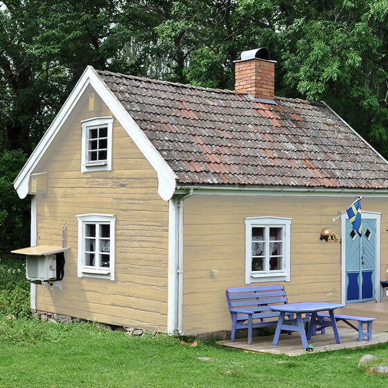 Holzhütte im Wald mit Lasur Creme gestrichen