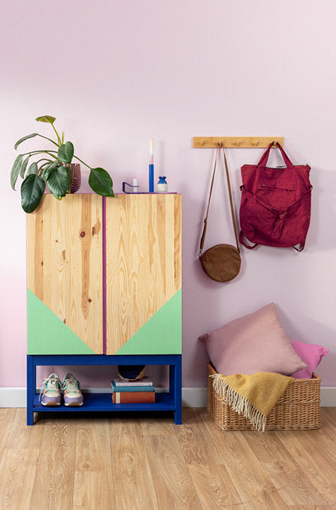 Bunt gestrichene IKEA Ivar Kommode in einem Flur vor einer rosafarbenen Wand